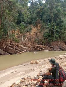 Ramadan Gustika berfoto di pinggir sungai yang tebingnya longsor