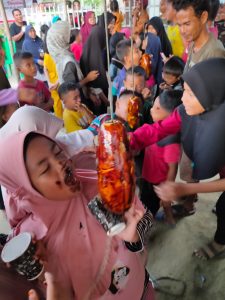 Serunya anak-anak yang ikut lomba mengambil koin dari buah pepaya (foto: Superman)